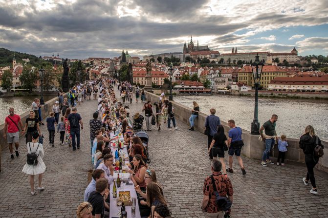 People sit at a giant table on the Charles Bridge in Prague, Czech Republic, on June 30. To celebrate the end of the country's lockdown, cafe owner Ondrej Kobza organized <a href="index.php?page=&url=https%3A%2F%2Fwww.cnn.com%2Ftravel%2Farticle%2Fczech-public-dinner-lockdown-scli-intl%2Findex.html" target="_blank">the dinner party.</a> "We want to celebrate the end of the coronavirus crisis with people meeting up and showing they're no longer afraid to meet others. That they aren't afraid to accept a bite of a sandwich from someone," Kobza told the Agence France-Presse news agency. The Czech Republic was quick to implement a lockdown at the start of the outbreak and became one of the first countries to tell its citizens to wear masks. That helped it avoid the worst of the pandemic and ease restrictions earlier than many other nations.