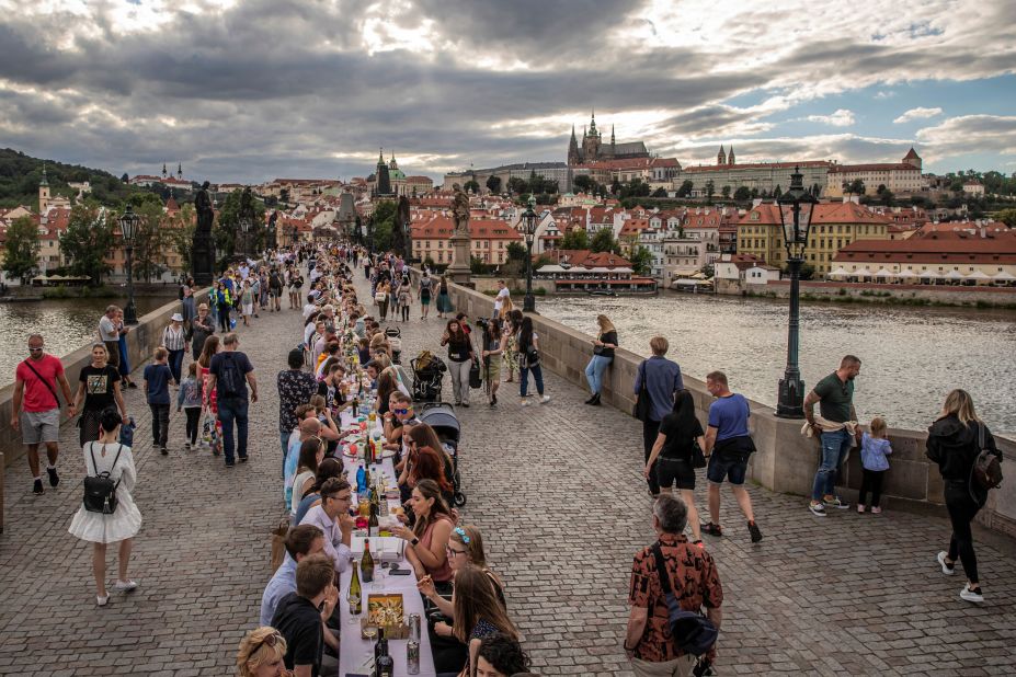 People sit at a giant table on the Charles Bridge in Prague, Czech Republic, on June 30. To celebrate the end of the country's lockdown, cafe owner Ondrej Kobza organized <a href="https://www.cnn.com/travel/article/czech-public-dinner-lockdown-scli-intl/index.html" target="_blank">the dinner party.</a> "We want to celebrate the end of the coronavirus crisis with people meeting up and showing they're no longer afraid to meet others. That they aren't afraid to accept a bite of a sandwich from someone," Kobza told the Agence France-Presse news agency. The Czech Republic was quick to implement a lockdown at the start of the outbreak and became one of the first countries to tell its citizens to wear masks. That helped it avoid the worst of the pandemic and ease restrictions earlier than many other nations.
