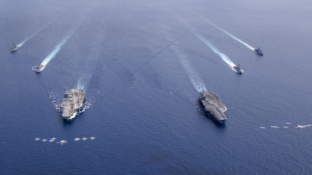 US planes fly in formation above the USS Nimitz and USS Ronald Reagan Carrier Strike Groups as they conduct dual carrier operations in the South China Sea.