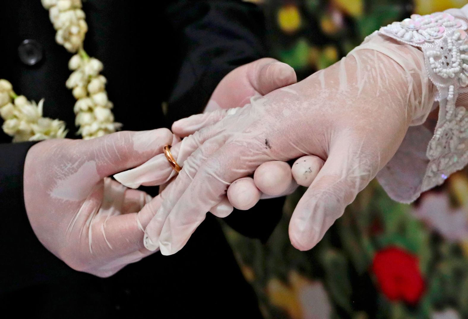 Octavianus Kristianto puts a ring on his new bride, Elma Divani, during their wedding ceremony in Pamulang, Indonesia, on June 19. They were wearing latex gloves to prevent the spread of the coronavirus.