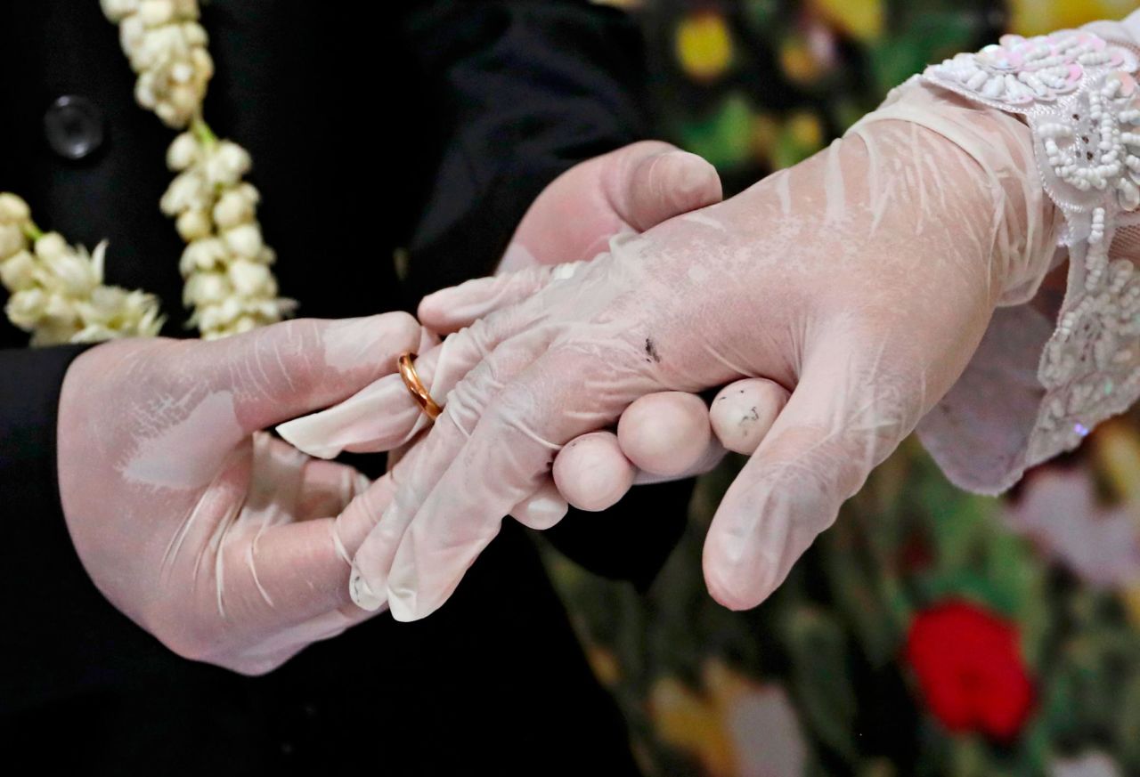 Octavianus Kristianto puts a ring on his new bride, Elma Divani, during their wedding ceremony in Pamulang, Indonesia, on June 19. They were wearing latex gloves to prevent the spread of the coronavirus.