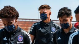 Members of Chicago Fire FC don masks on the way to training 