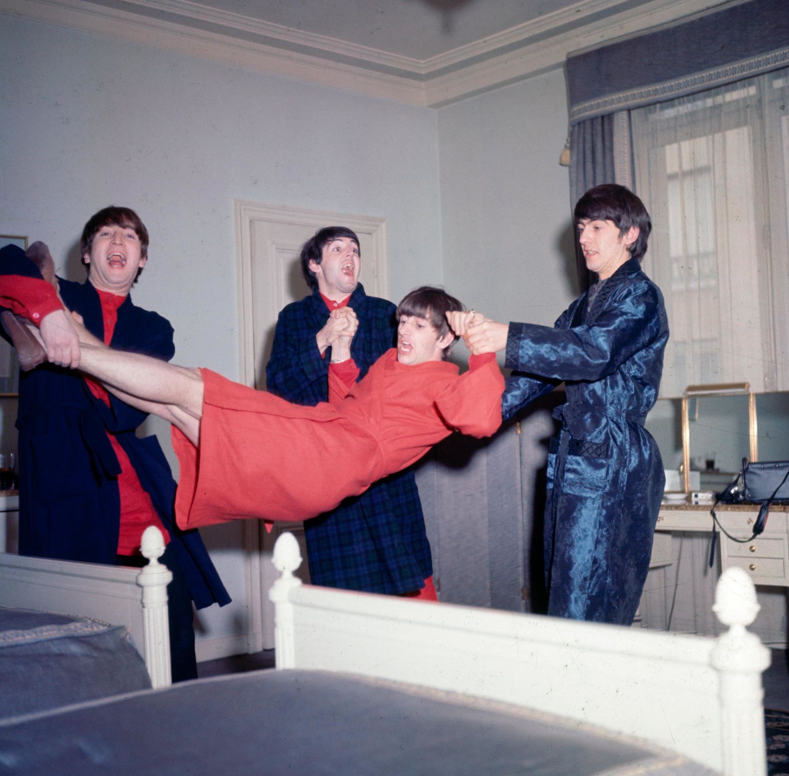 The Beatles horse around with Starr while in Paris in January 1964.