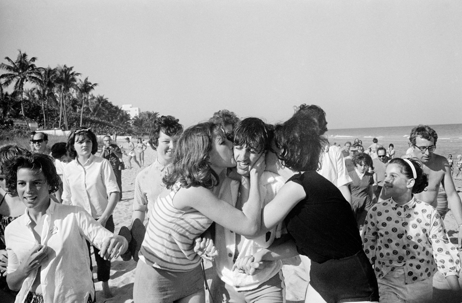 Starr is besieged by schoolgirls as he strolls on a beach in Miami in February 1964.