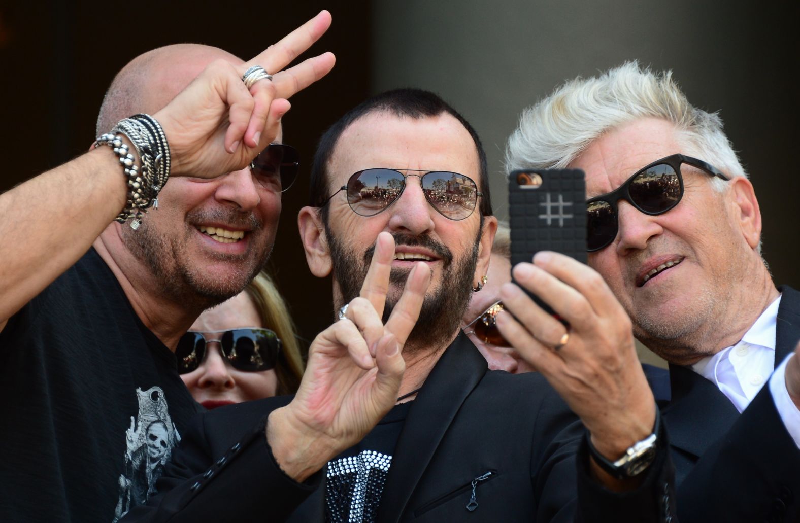 Starr takes a selfie with fashion designer John Varvatos, left, and film director David Lynch while celebrating his 74th birthday in July 2014. Starr's wife, Barbara, is in the back.
