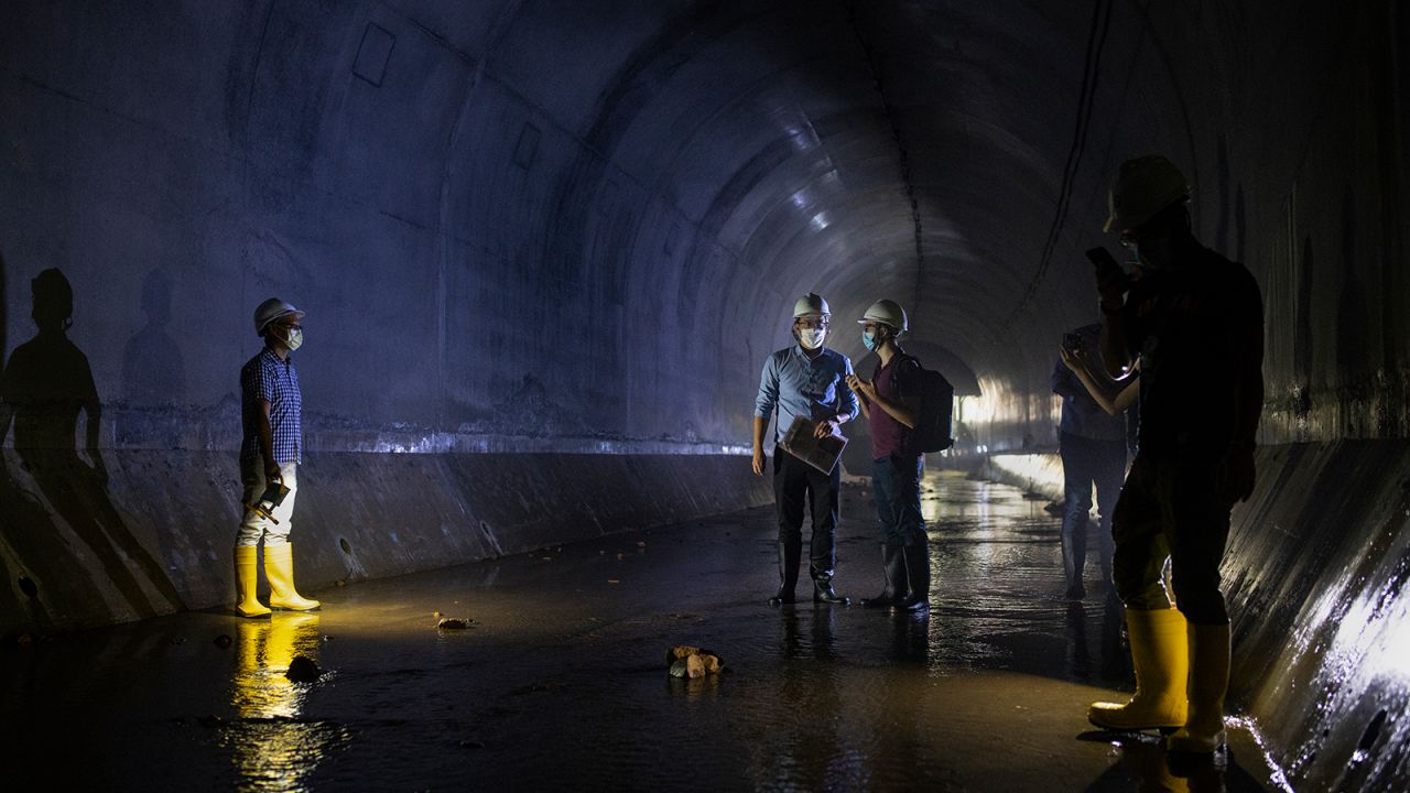Hong Kong Drainage Services Department employees stand inside the tunnel, near the neighborhood of Tai Hang.'