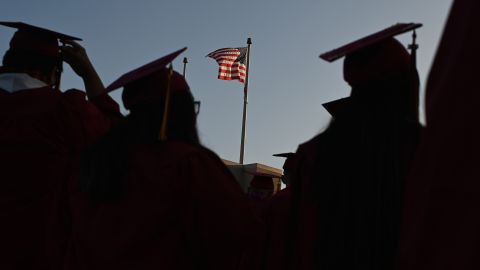 A US flag flies above a building as students earning degrees at Pasadena City College participate in the graduation ceremony, June 14, 2019, in Pasadena, California. 