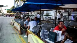 People eat in the outdoor dining area of a restaurant on Ocean Drive in Miami Beach, Florida on June 24, 2020. - With coronavirus cases surging across the US South and West, officials are once again imposing tough measures, from stay-at-home advice in worst-hit states to quarantines to protect recovering areas like New York. Nearly half of the 50 US states have seen an increase in infections over the past two weeks, with some -- such as Texas and Florida -- posting daily records. (Photo by CHANDAN KHANNA / AFP) (Photo by CHANDAN KHANNA/AFP via Getty Images)