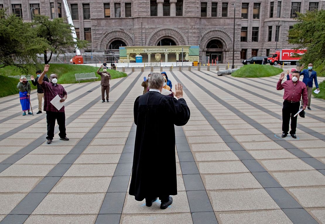 Chief Judge John R. Tunheim leads a group in the oath of allegiance during a naturalization ceremony at Federal Plaza in Minneapolis, Minnesota, on May 27. 