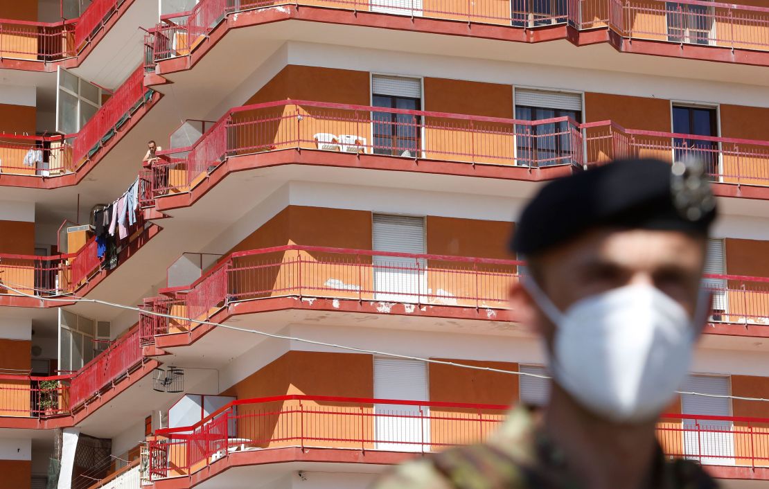 A soldier stands in front of a building where dozens of Covid-19 cases were registered among a community of farm workers, in Mondragone, in the southern Italian region of Campania.