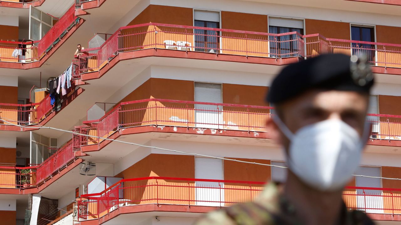 A soldier stands in front of a building where dozens of Covid-19 cases were registered among a community of farm workers, in Mondragone, in the southern Italian region of Campania.