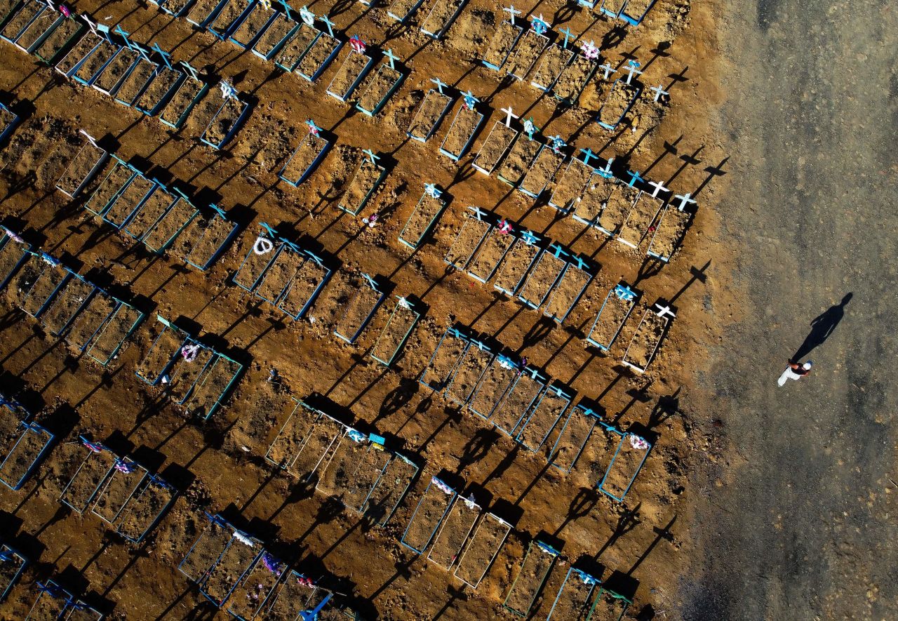 This aerial photo shows a man walking past graves in the Nossa Senhora Aparecida cemetery in Manaus, Brazil, on June 21.