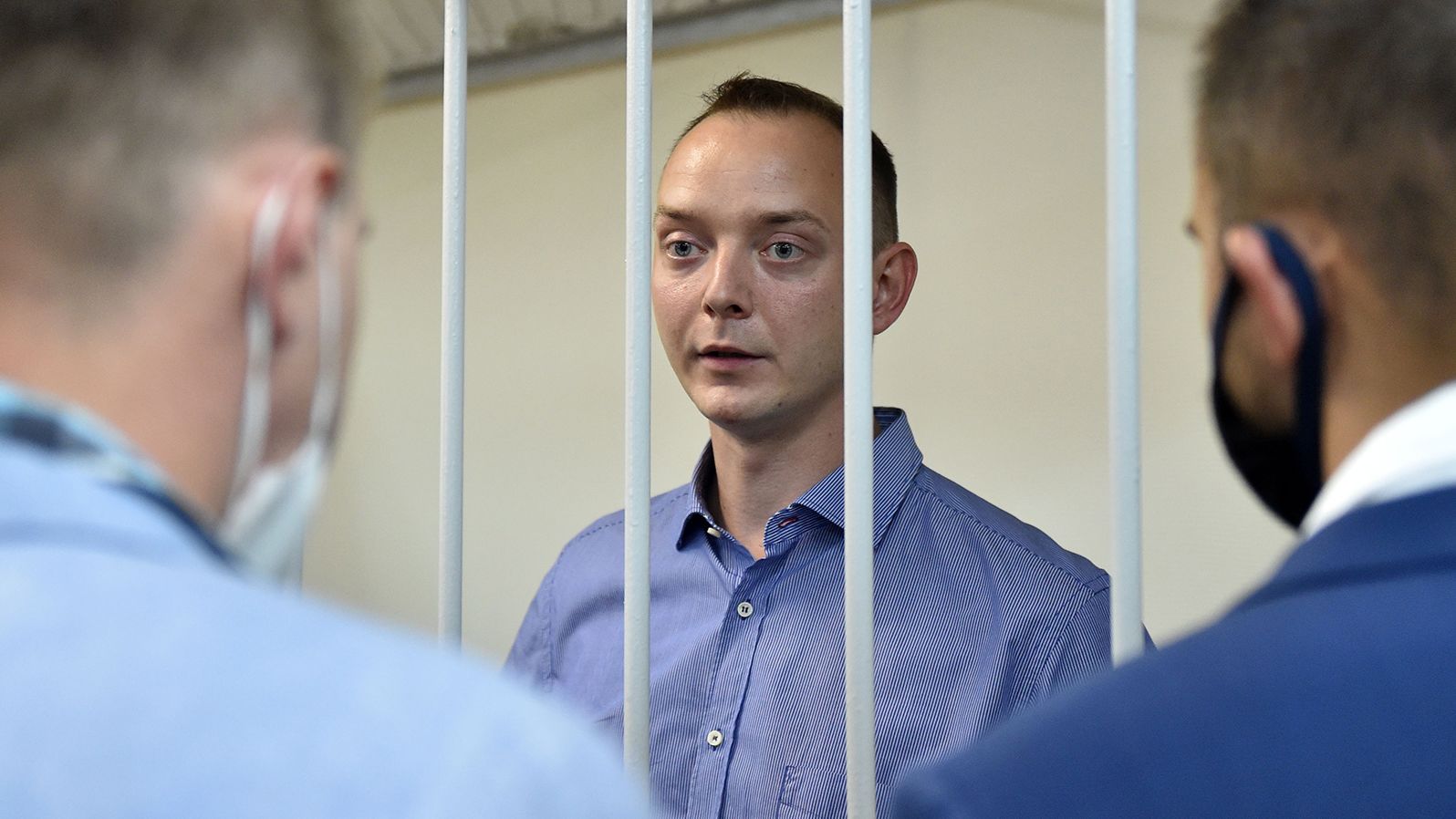 Ivan Safronov, an aide to the head of Russia's space agency Roscosmos, stands inside a defendants' cage during a court hearing in Moscow on July 7