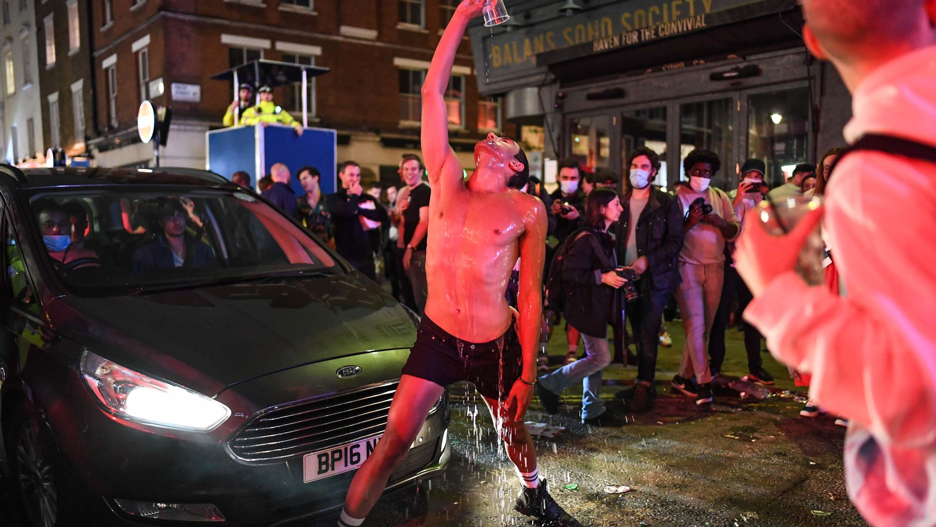A man pours water over himself in London's Soho neighborhood on July 4 — the day pubs, hotels and restaurants <a href="https://www.cnn.com/2020/07/04/uk/uk-pubs-reopening-saturday-scli-gbr-intl/index.html" target="_blank">were allowed to reopen</a> in the United Kingdom.