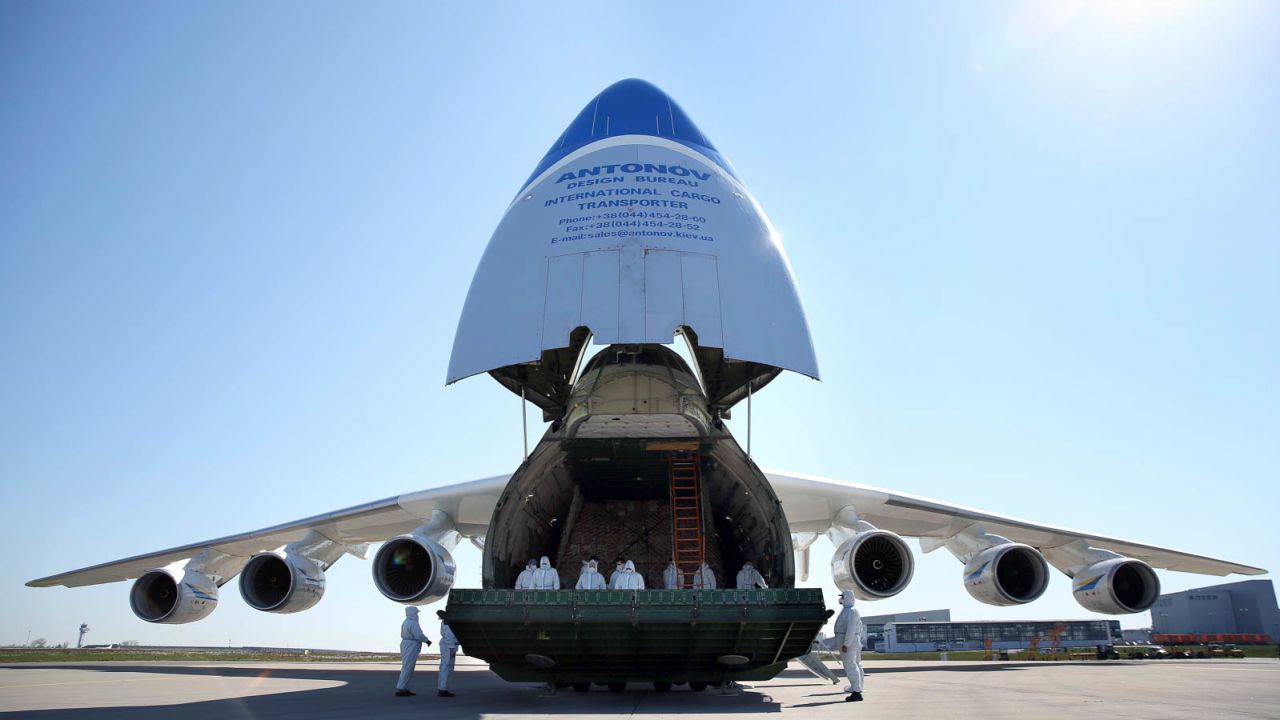 Crew members in protective suits stand inside an Antonov An-225 Mriya cargo aeroplane during a delivery of protective masks from China.