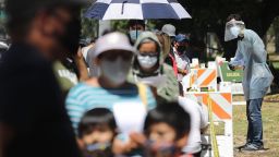 LOS ANGELES, CALIFORNIA  - JULY 07: A COVID-19 testing associate dressed in personal protective equipment (PPE) assists people waiting in line at a testing center at Lincoln Park amid the coronavirus pandemic on July 07, 2020 in Los Angeles, California. There has been a spike in new coronavirus cases in California along with an increase in the number of hospitalizations and positivity rate. (Photo by Mario Tama/Getty Images)