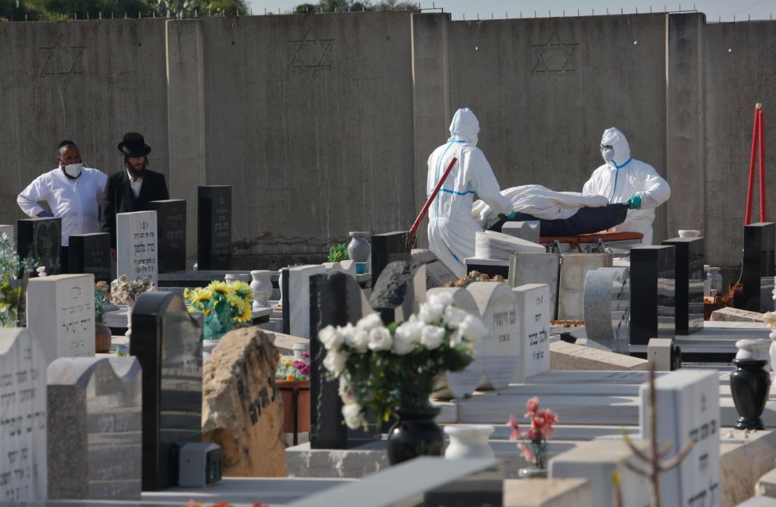 Funeral workers carry the body of a Covid-19 patient at a cemetery in the central Israeli city of Rehovot on April 21.