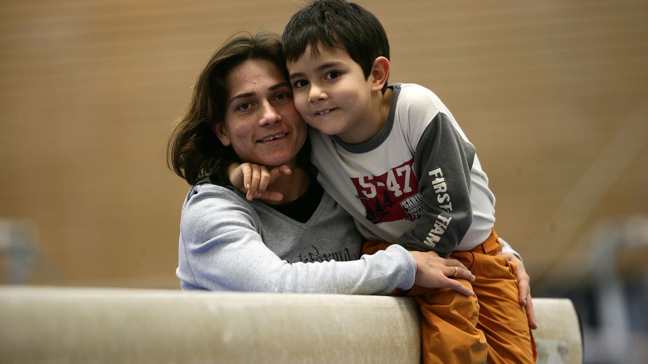 Chusovitina holds her son Alisher before practice in Cologne, Germany.