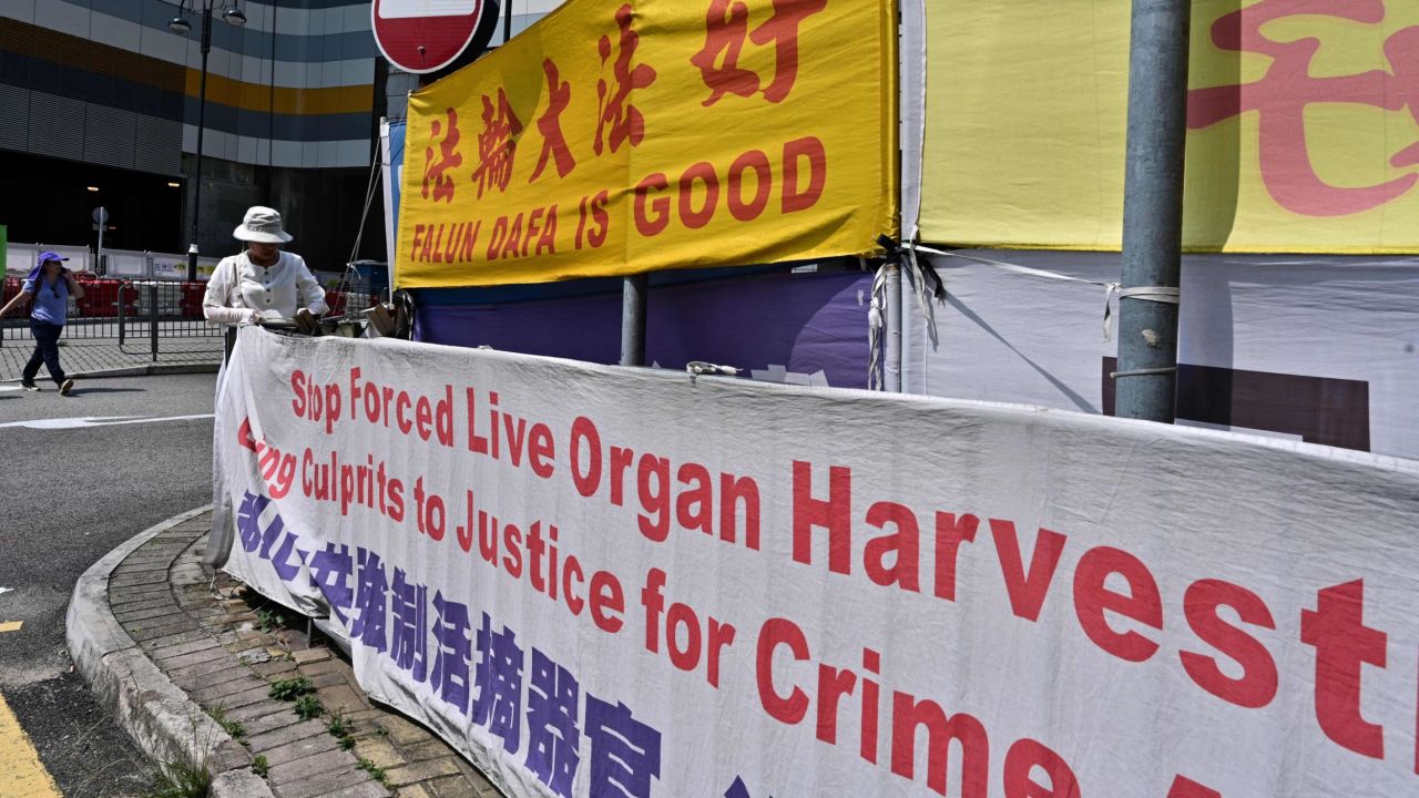 A woman adjusts banners in support of Falun Gong in Tung Chung, an area popular with tourists from the mainland, in Hong Kong on April 25, 2019.