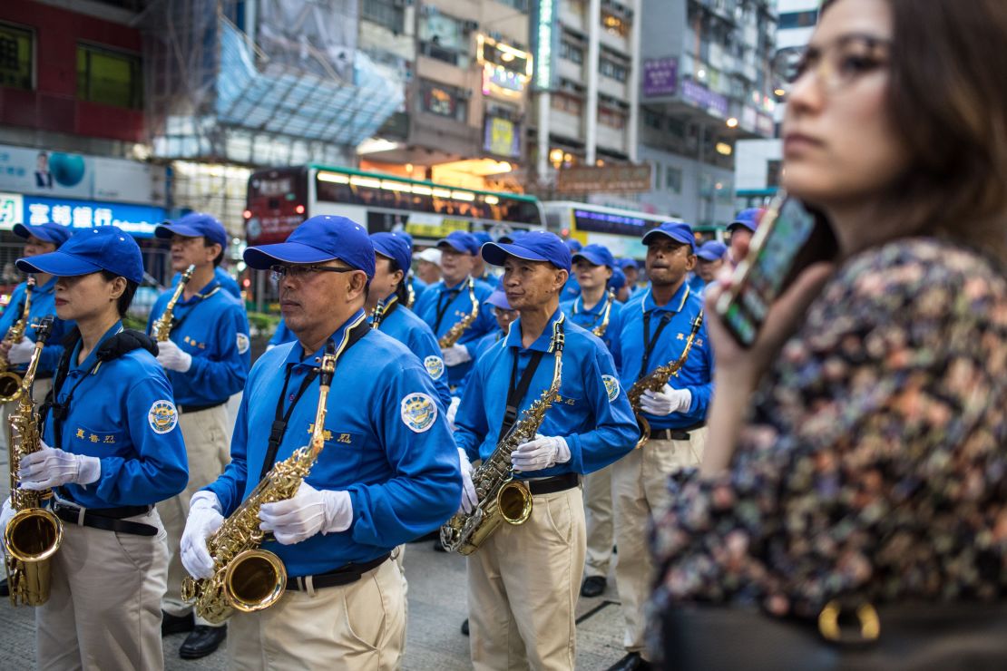 A woman watches as supporters of the Falun Gong spiritual group, banned in mainland China, take part in a march in Hong Kong on April 27, 2019, to observe the 20th anniversary of a large demonstration in Beijing which led to a crackdown against the movement.