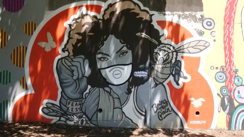 Artist Dubelyoo covered his mural of a woman boxer with a vinyl mask in Atlanta's Cabbagetown neighborhood as a visual reminder to wear a mask to fight Covid-19. 