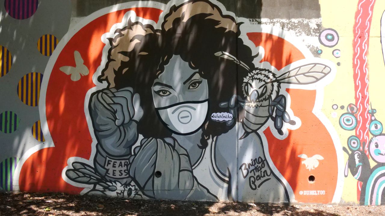 Artist Dubelyoo covered his mural of a woman boxer with a vinyl mask in Atlanta's Cabbagetown neighborhood as a visual reminder to wear a mask to fight Covid-19.