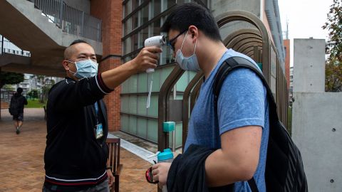 Taiwanese students get their temperature checked as they enter the Taipei American school on March 18, 2020 in Taipei, Taiwan. 