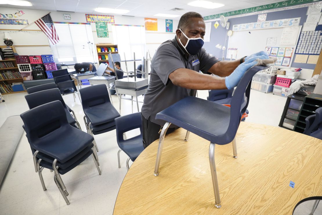 Des Moines Public Schools custodian Tracy Harris cleans classroom chairs at Brubaker Elementary School.