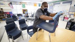 Des Moines Public Schools custodian Tracy Harris cleans chairs in a classroom at Brubaker Elementary School, on Wednesday, July 8, 2020, in Des Moines, Iowa. 