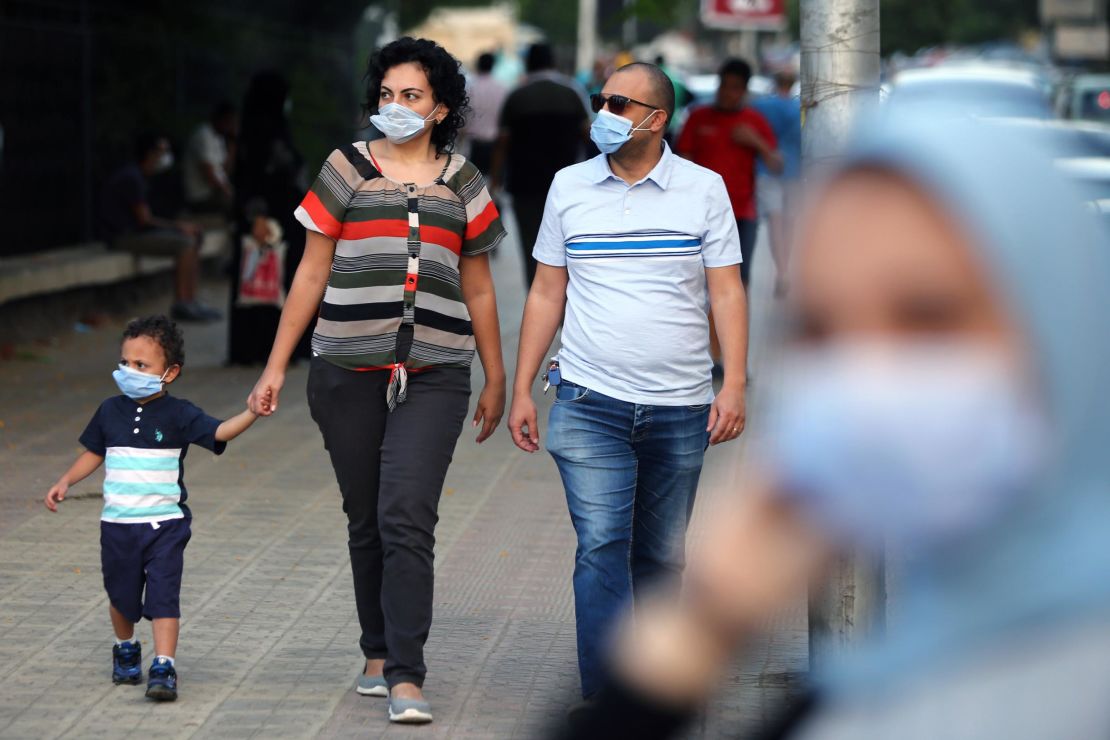 People wearing face masks walk on a street in Cairo, Egypt, on June 12.