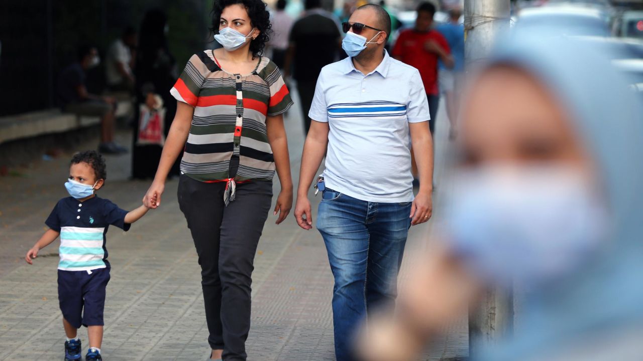 People wearing face masks walk on a street in Cairo, Egypt, on June 12.