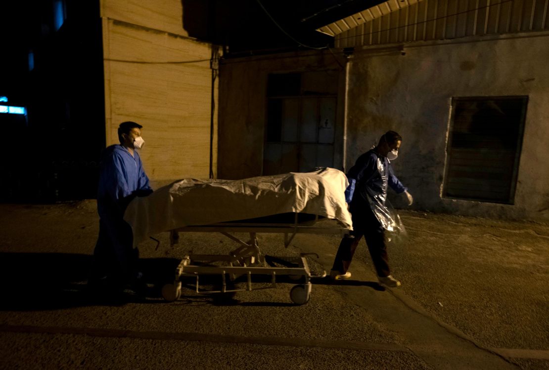 Two Iranian hospital personnel carry bodies to a morgue in southern Tehran on June 20. 