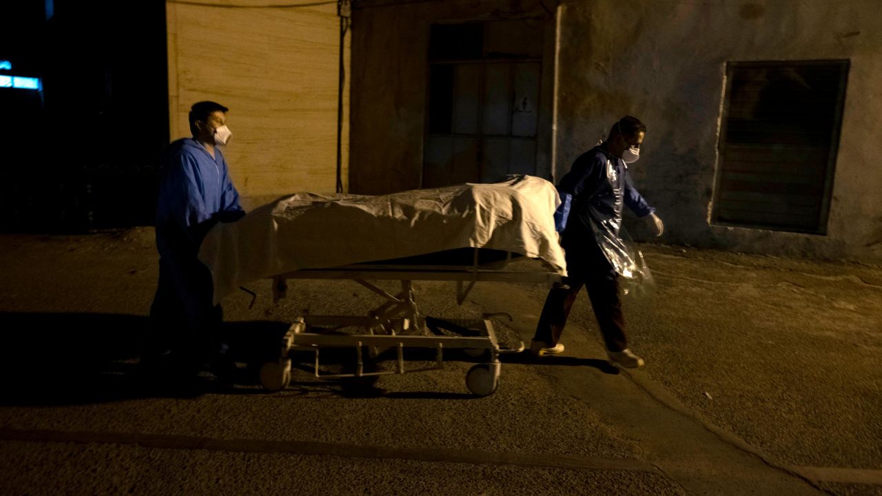 Two Iranian hospital personnel carry bodies to a morgue in southern Tehran on June 20. 