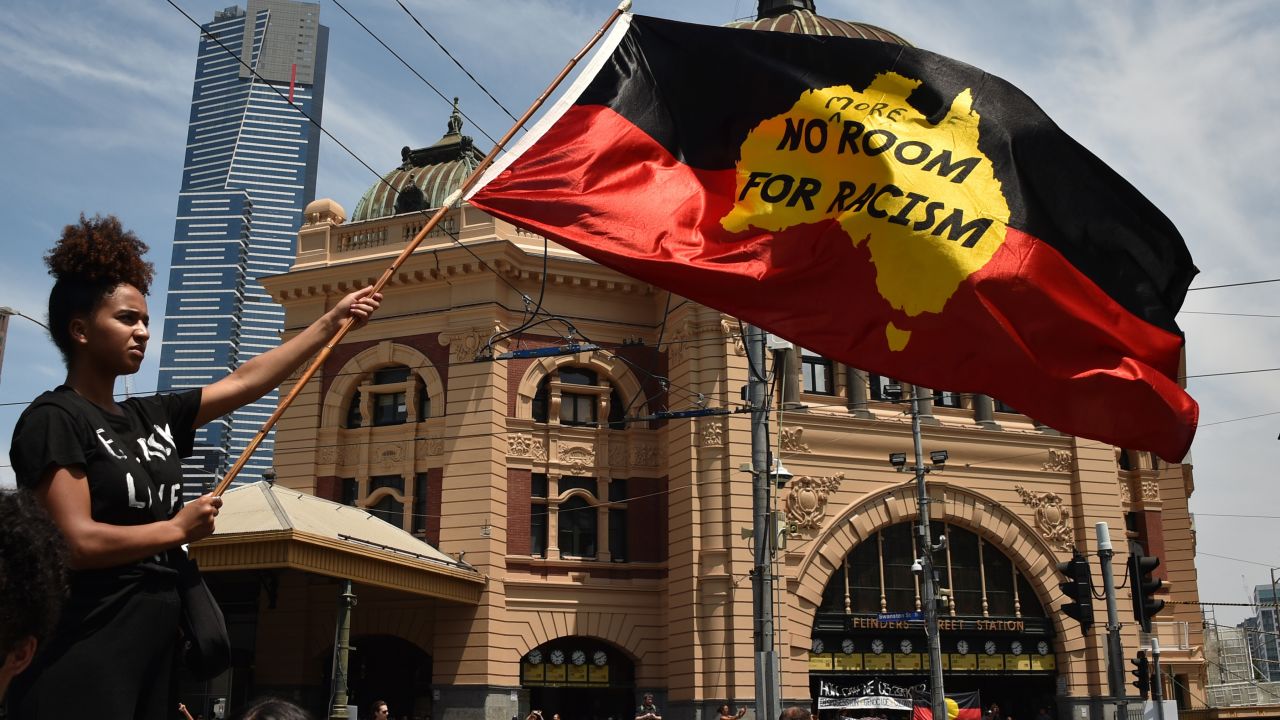 A woman waves the Aboriginal flag on January 26, 2018, during a rally to mark what many Indigeous Australians call "Invasion Day."