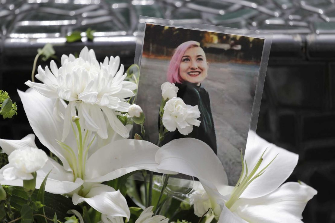 A photo of Summer Taylor, who suffered fatal injuries after she was hit by a car while protesting, sits among flowers at the King County Correctional Facility, where a hearing was held this week for the suspect in her death.