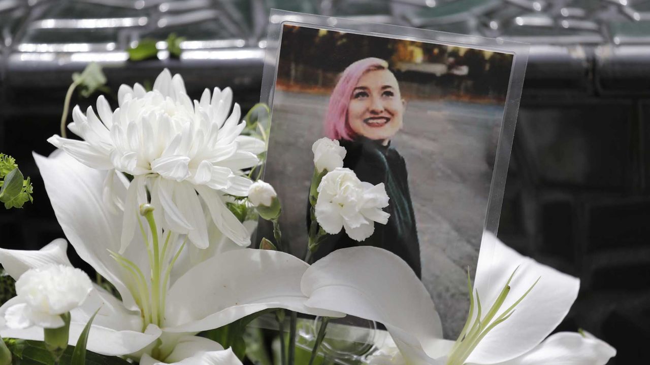 A photo of Summer Taylor, who suffered fatal injuries after she was hit by a car while protesting, sits among flowers at the King County Correctional Facility, where a hearing was held this week for the suspect in her death.
