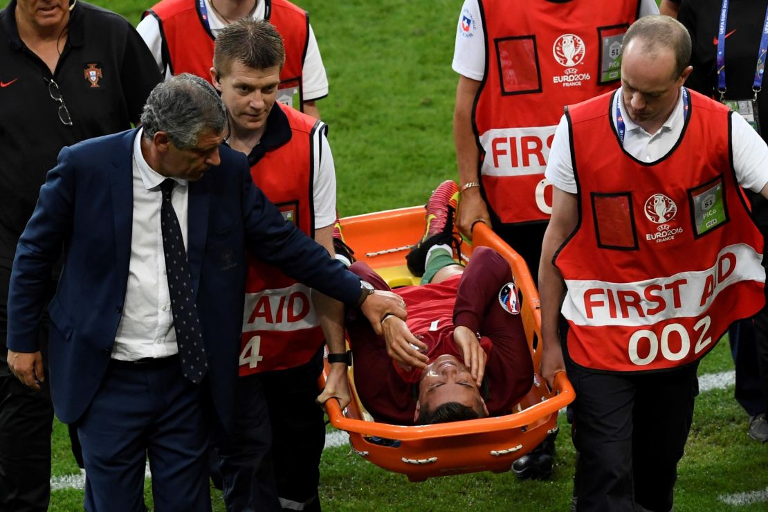 Cristiano Ronaldo is comforted by Portugal coach Fernando Santos as leaves the field on a stretcher during the Euro 2016 final.