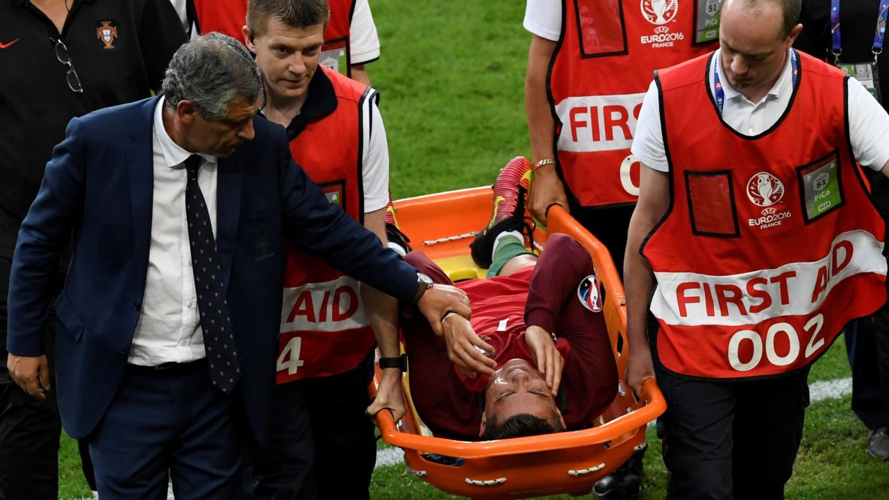 Cristiano Ronaldo is comforted by Portugal coach Fernando Santos as leaves the field on a stretcher during the Euro 2016 final.