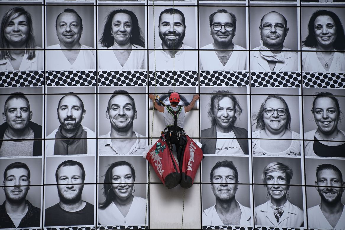 Portraits of health-care workers are pasted on the facade of the Opera Bastille in Paris on Wednesday, July 8.