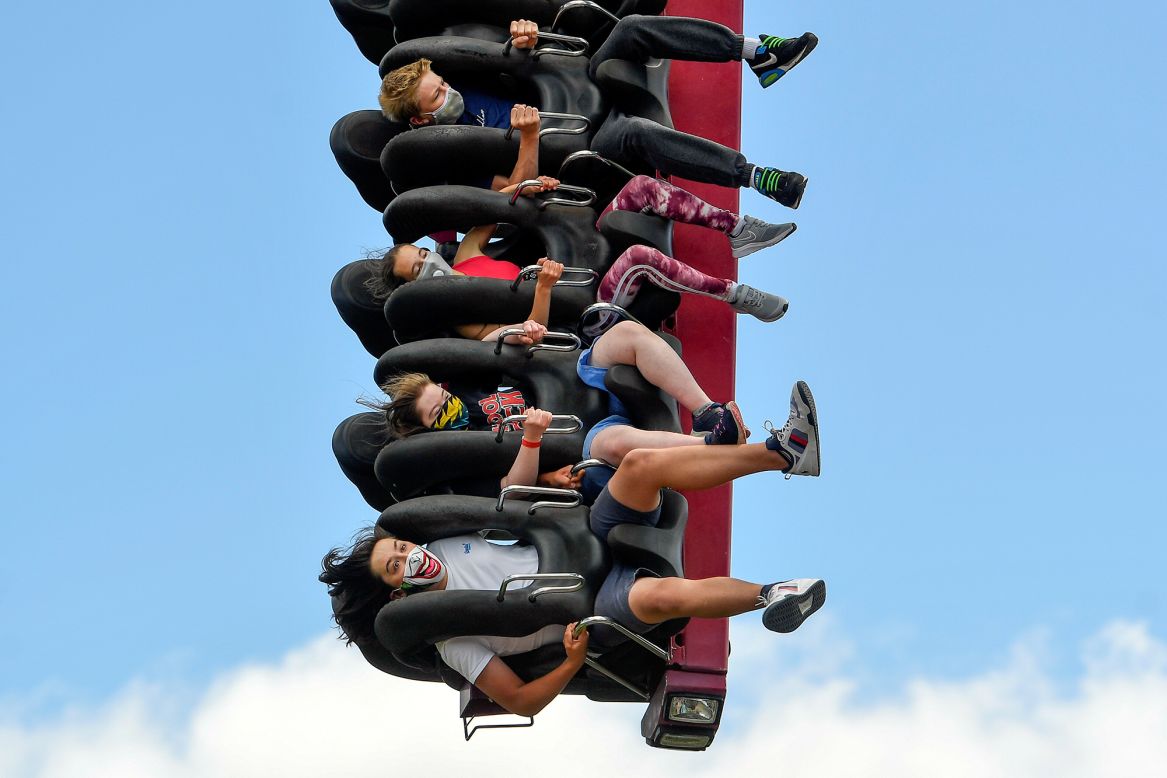 People in Chertsey, England, wear protective masks as they enjoy an amusement ride in Thorpe Park on Sunday, July 5.