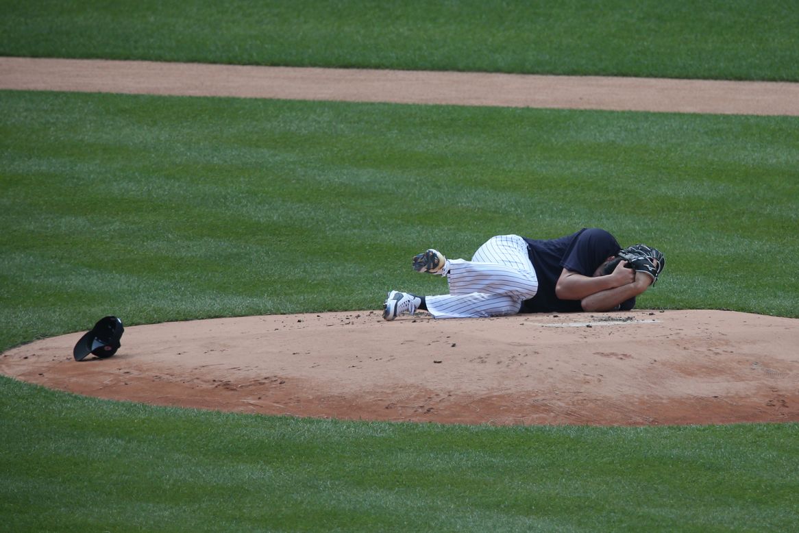 New York Yankees pitcher Masahiro Tanaka lies on the mound after he was hit in the head by a teammate's line drive during a workout at Yankee Stadium on Saturday, July 4. He suffered a mild concussion, Yankees Manager Aaron Boone said.
