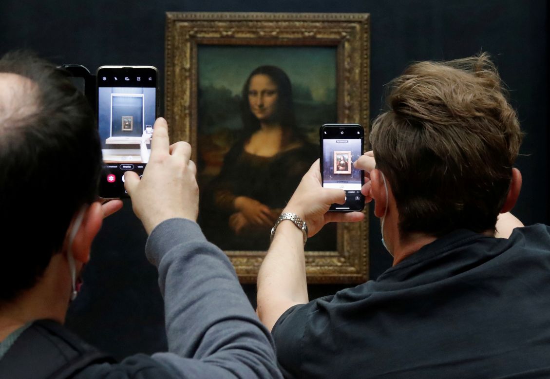 Visitors take photos of the "Mona Lisa" at the Louvre in Paris on Monday, July 6. The Louvre, the world's most popular museum, <a href="https://www.cnn.com/travel/article/louvre-reopens-july/index.html" target="_blank">has reopened its doors</a> after months of closure.