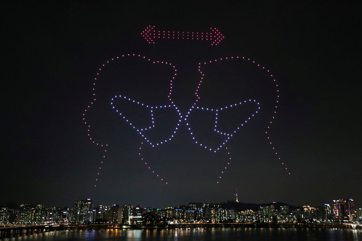 Drones show a message about social distancing as they fly over the Han River in Seoul, South Korea, on Saturday, July 4.