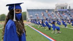 A student prepares to walk in a graduation ceremony at Millburn High School in Millburn, N.J., Wednesday, July 8, 2020. This week New Jersey saw the resumption of youth day camps, in-person summer school and school graduation ceremonies, capped at 500 people and required to be outside. (AP Photo/Seth Wenig)