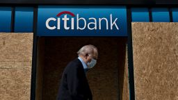 A pedestrian wearing a protective mask walks past a boarded up Citigroup Inc. Citibank branch in Washington, D.C., U.S., on Thursday, June 4, 2020. Mayor Muriel Bowser lifted the curfew in D.C. for Thursday, the Washington Post reported. Photographer: Andrew Harrer/Bloomberg via Getty Images