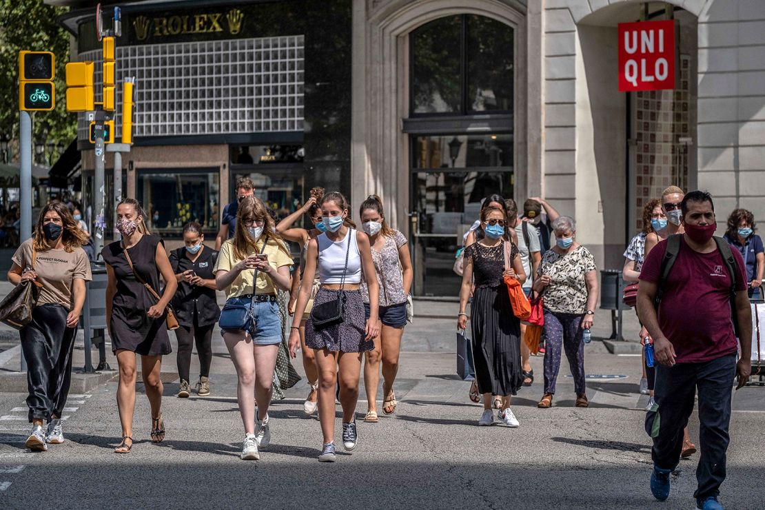 People wear face masks in Barcelona, Spain, where those who don't do so in a public space face a 100 euro fine.