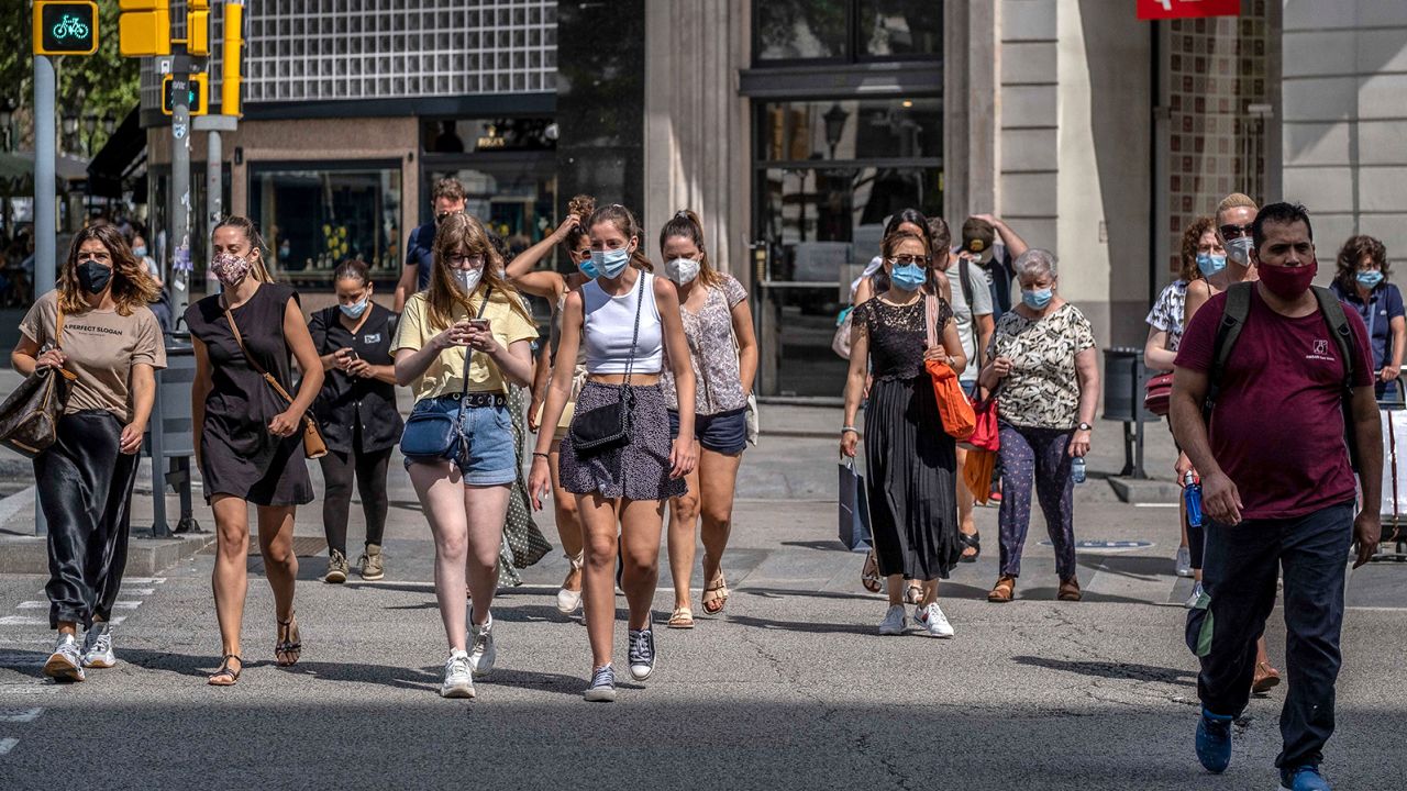 People wear face masks in Barcelona, Spain, where those who don't do so in a public space face a 100 euro fine.