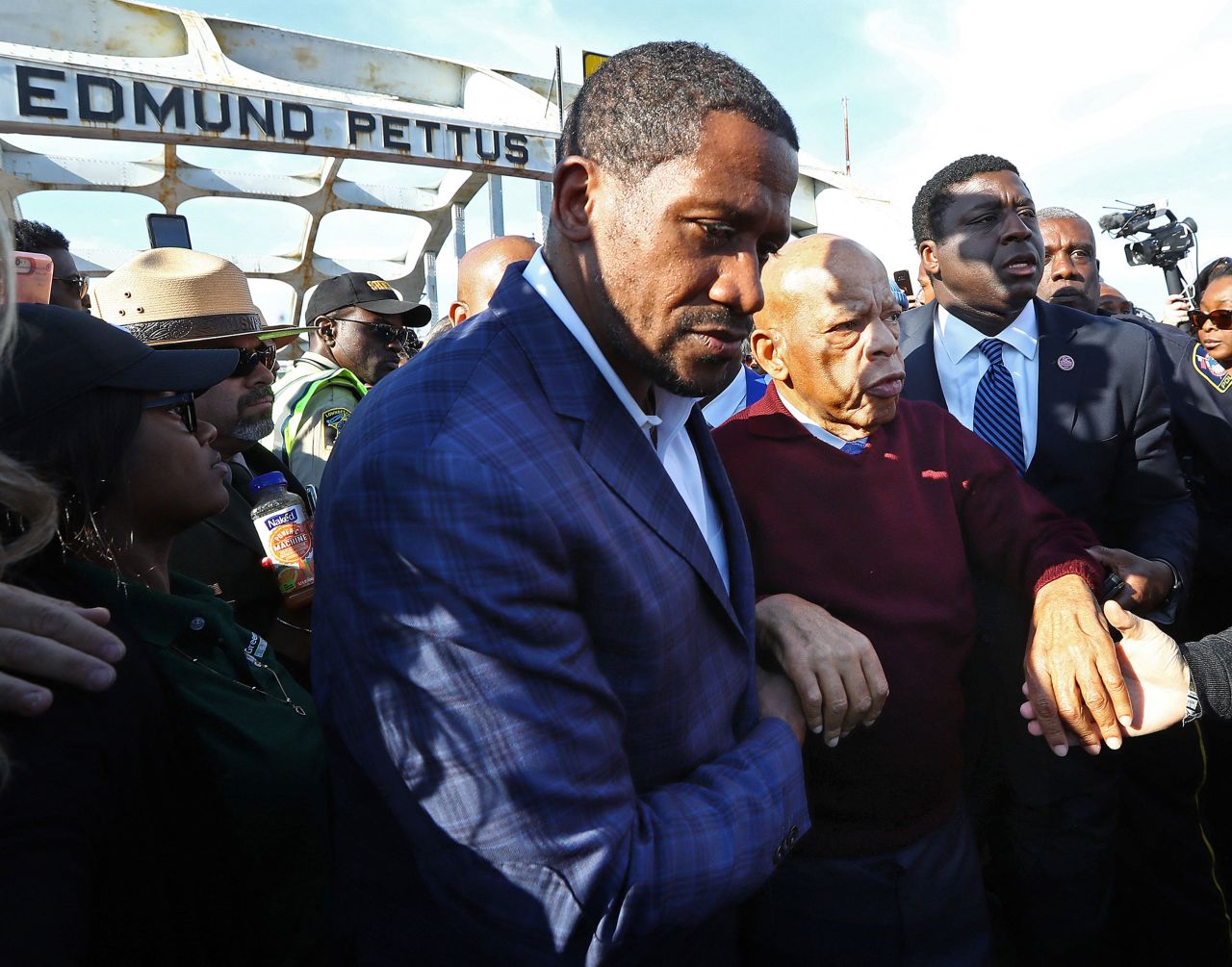 Lewis is assisted near Selma's Edmund Pettus Bridge while attending a March 2020 ceremony marking the 55th anniversary of "Bloody Sunday." A few months earlier, Lewis' office announced that he had been diagnosed with stage 4 pancreatic cancer.