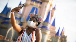 LAKE BUENA VISTA, FL - JULY 11:  In this handout photo provided by Walt Disney World Resort, a guest stops to take a selfie at Magic Kingdom Park at Walt Disney World Resort on July 11, 2020 in Lake Buena Vista, Florida. July 11, 2020 is the first day of the phased reopening. (Photo by Olga Thompson/Walt Disney World Resort via Getty Images)