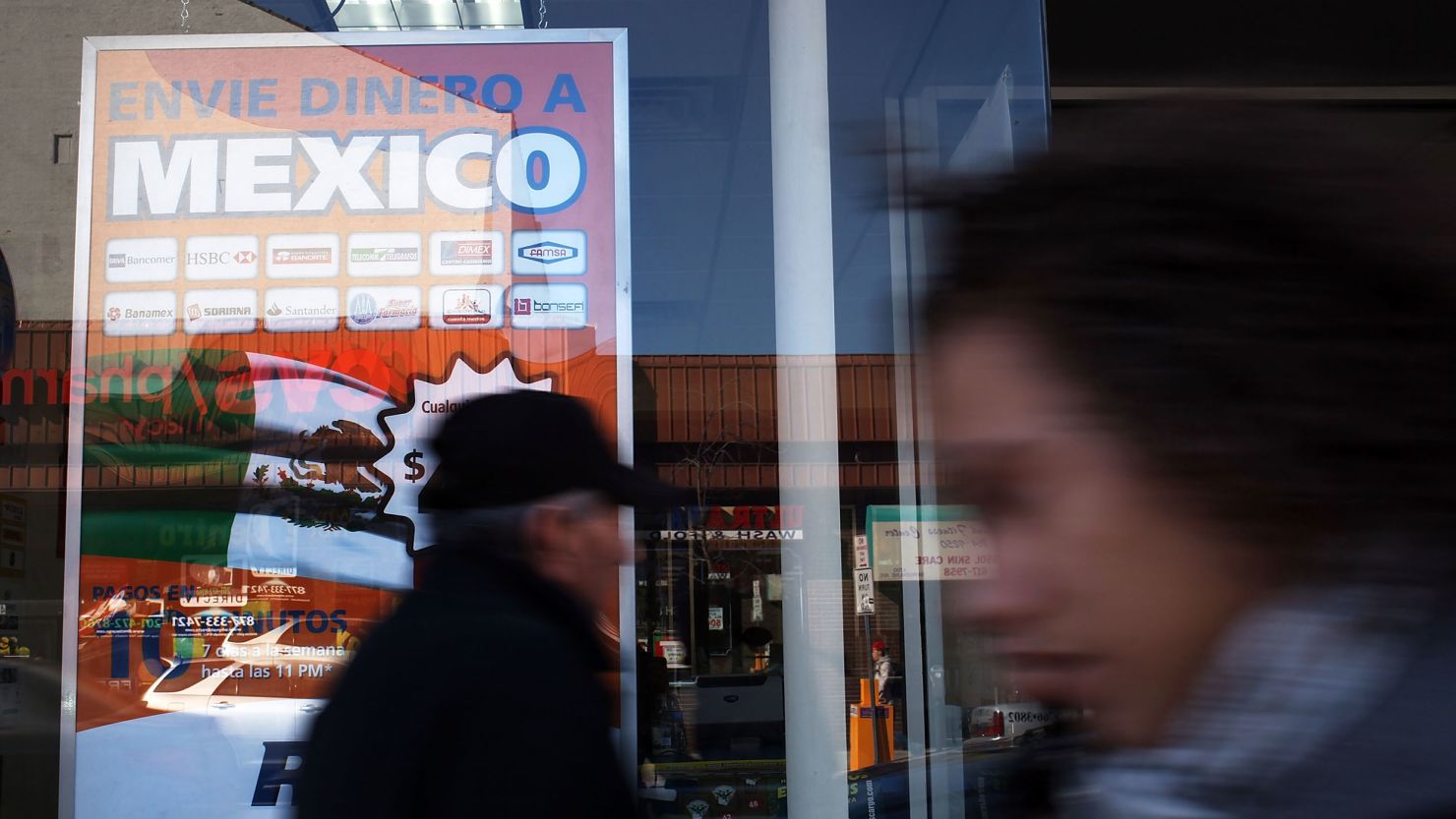 Money transfer advertisements are viewed in the window of a money transfer service specializing in transfers to Latin America on March 28, 2011. Remittances to Mexico alone in 2019 were worth nearly $39 billion.